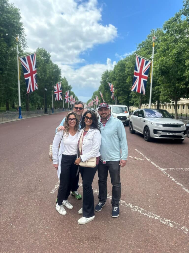 Group enjoying London sightseeing with Best Car Service London, featuring Union Jack flags and iconic streets.