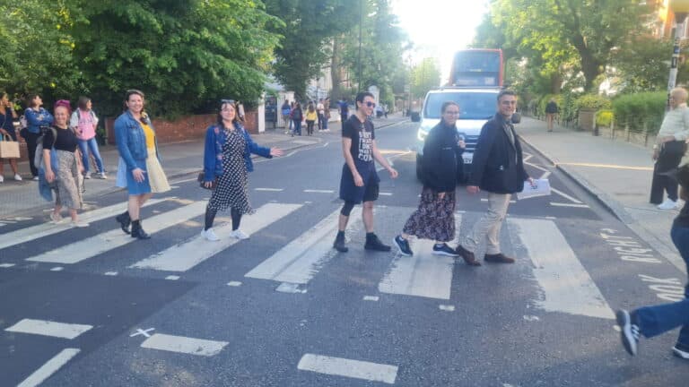 Explore London with a group crossing the iconic Abbey Road zebra crossing.