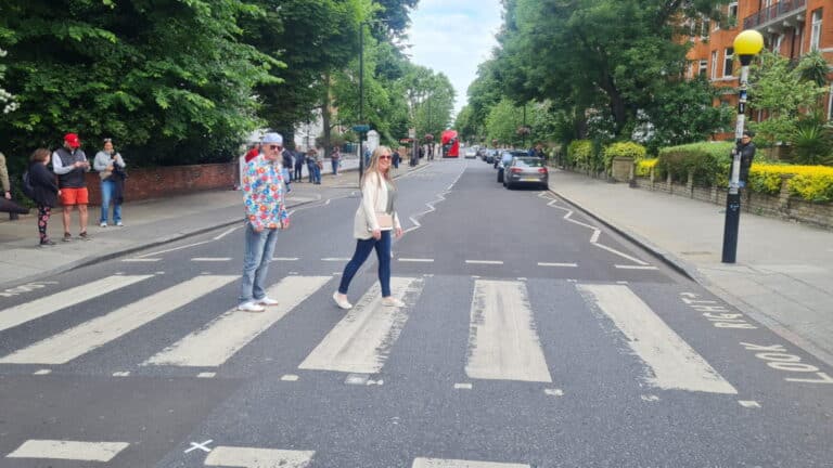 Visitors enjoying a London 1 Day Tour crossing the famous Abbey Road zebra crossing.