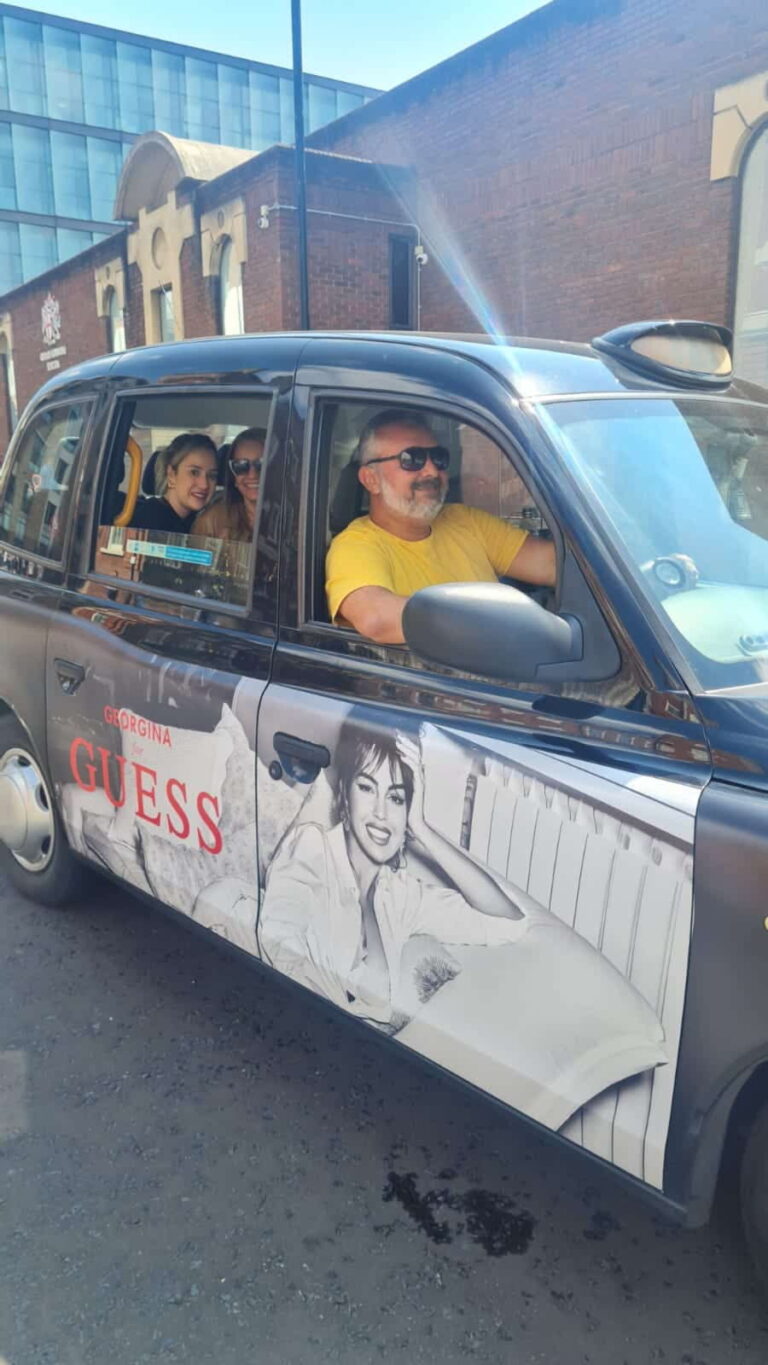 Tourists enjoying a London City Places tour in a branded taxi with Guess advertisement