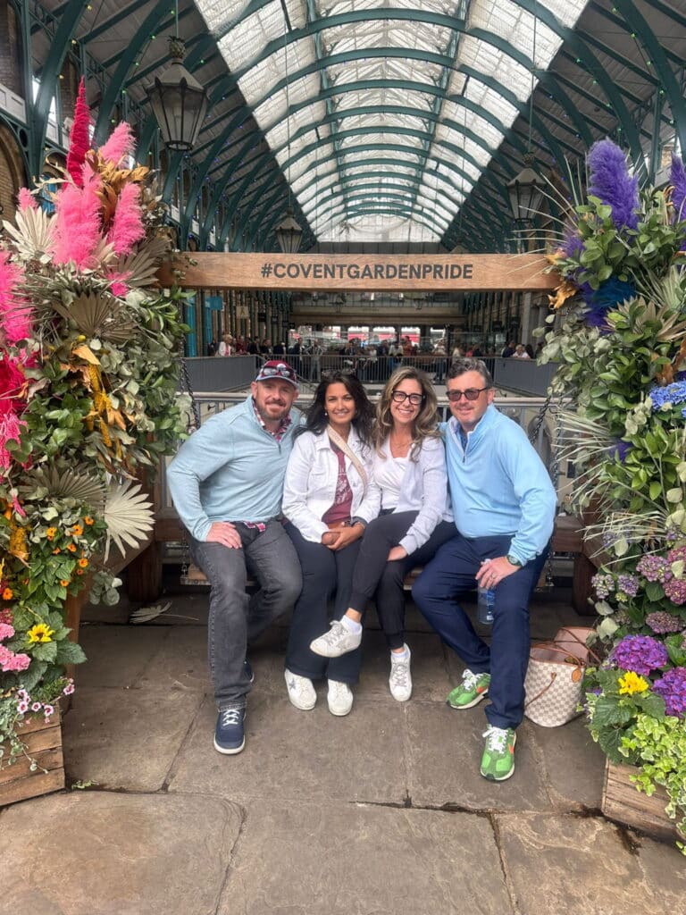 Visitors at Covent Garden, one of the Top 10 Tourist Spots In London, surrounded by vibrant floral decorations.