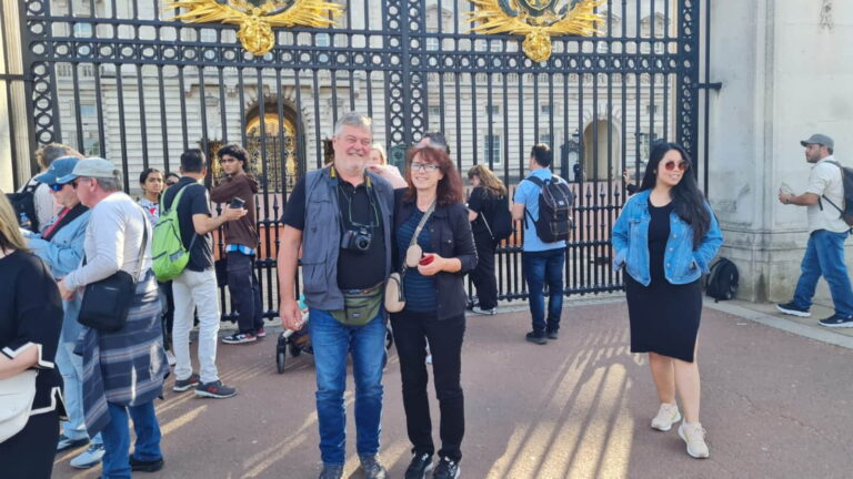 Tourists enjoying Top 10 Tourist Places in London with a stop at Buckingham Palace's iconic gates