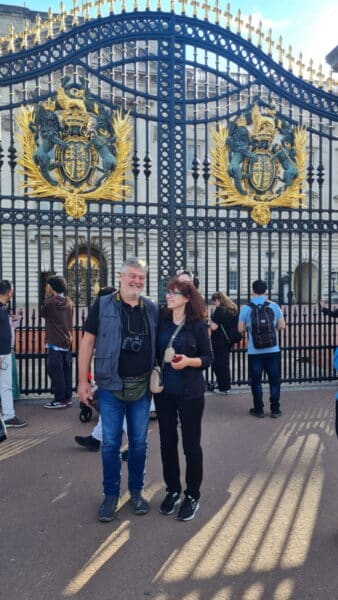 Visitors enjoying Sightseeing Tours in London England in front of Buckingham Palace gates.