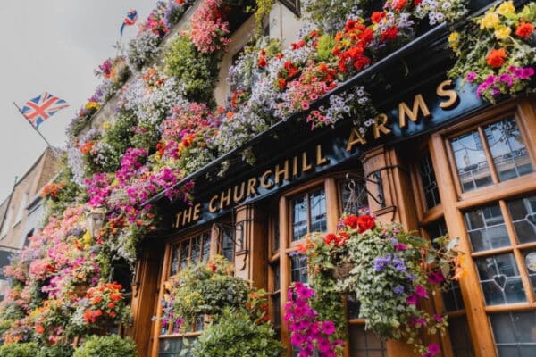Tour Operators In London England showcasing The Churchill Arms pub adorned with vibrant flowers
