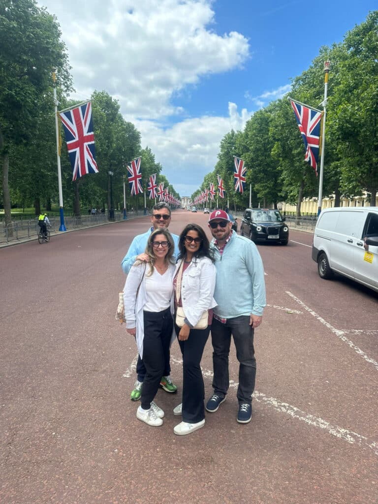 Group enjoying a Travel Itinerary to London with sightseeing taxi tours on The Mall, surrounded by Union Jack flags.