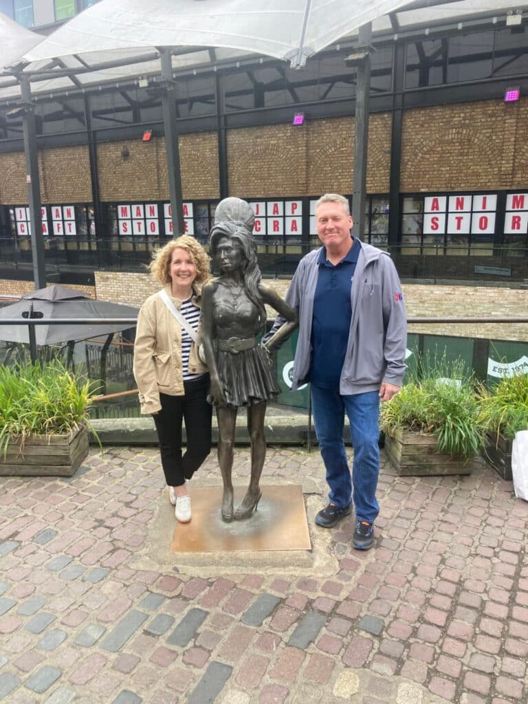 Tourists posing with a statue at a famous location in London