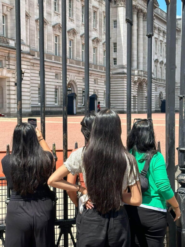 Visitors enjoying London Sightseeing Packages at Buckingham Palace gates