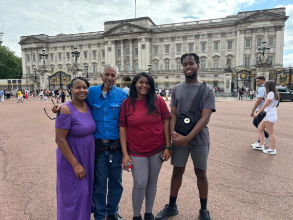 Family enjoying Travels In London with a London Sightseeing Taxi Tour in front of Buckingham Palace.