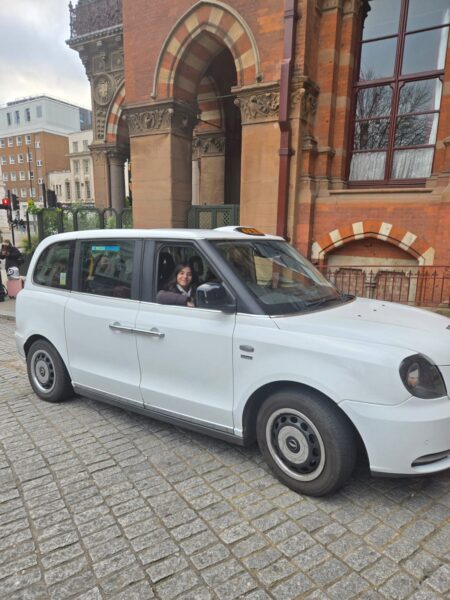 White taxi used for VIP Tours London parked near a historic building
