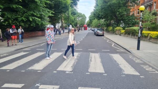 Visitors enjoying a London 2 Day Tour Package at a famous pedestrian crossing in the city.
