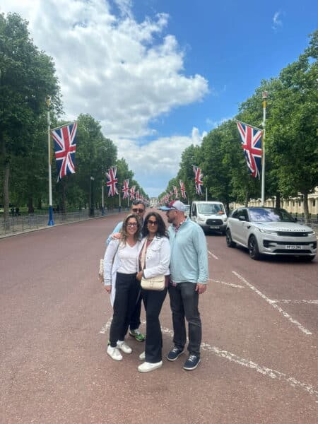 Group of tourists enjoying London sightseeing with Union Jack flags along The Mall, highlighting Book Activities In London
