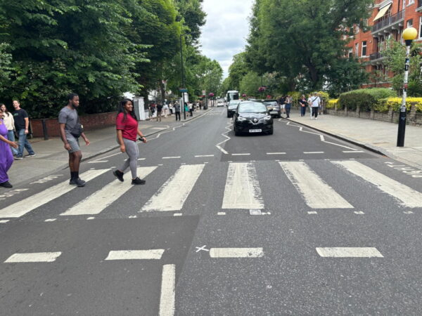Premier Tour London experience with visitors crossing a zebra crossing near iconic landmarks