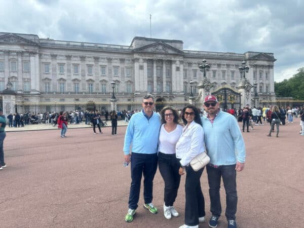Tourists enjoying a Free City Tour London experience with a view of the iconic Buckingham Palace