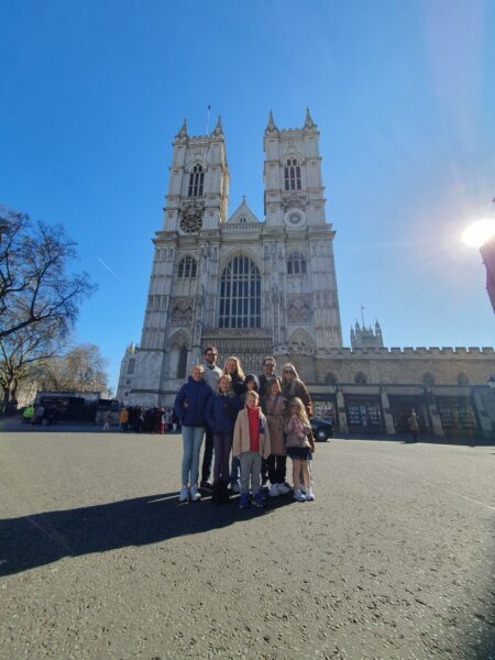 Family group enjoying City Tours London England in front of Westminster Abbey with London Sightseeing Taxi Tours