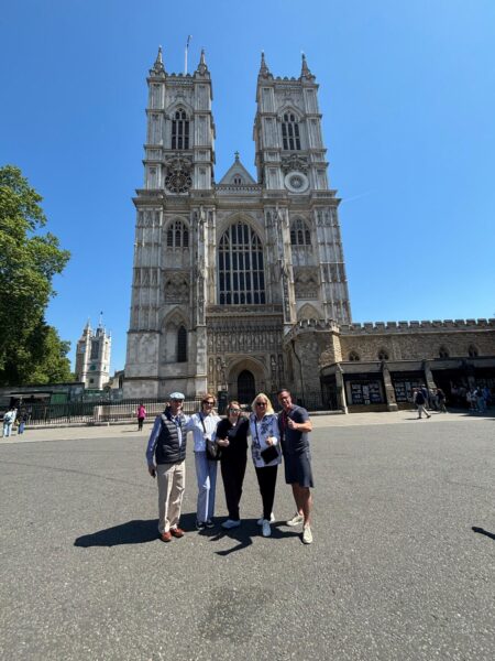 Best sight seeing in London - tourists pose in front of Westminster Abbey during guided taxi tour