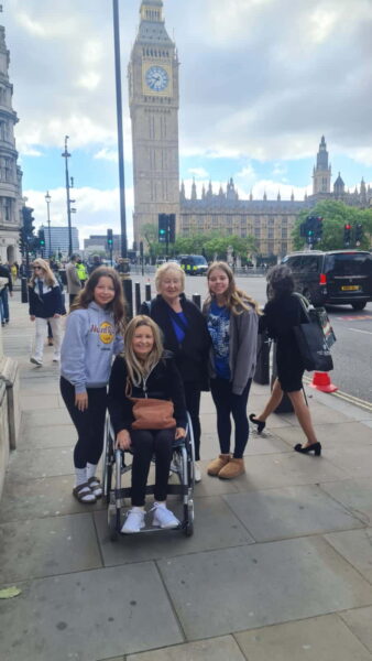 Family enjoying a Free Tour London En Espaol experience with wheelchair accessibility in front of Big Ben and Houses of Parliament