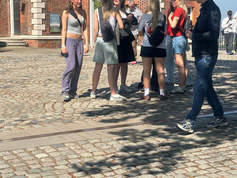 Young tourists gathering outside a historic London building during a London Nightlife Tour