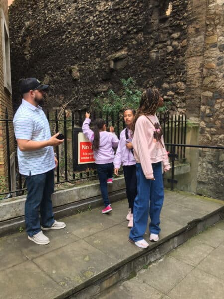 Group enjoying a Harry Potter London Free Tour with London Sightseeing Taxi Tours near historic stone walls