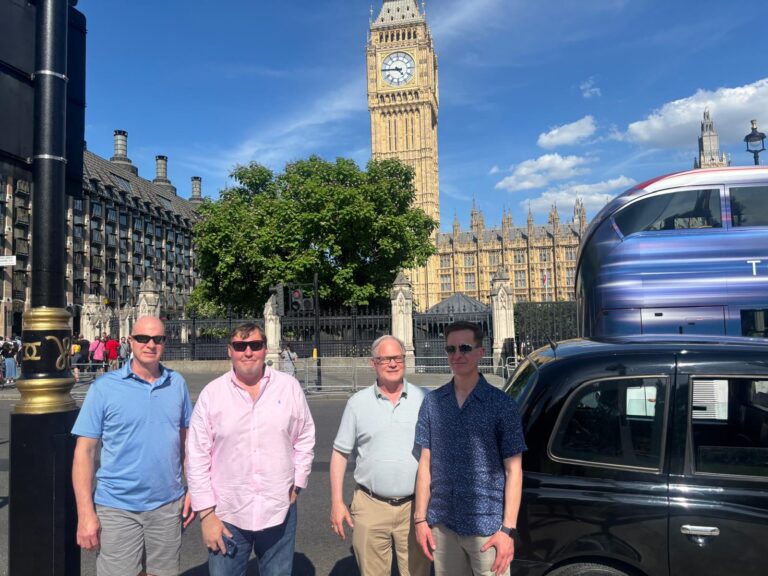 A family taking an iconic landmarks taxi tour London at Buckingham Palace.