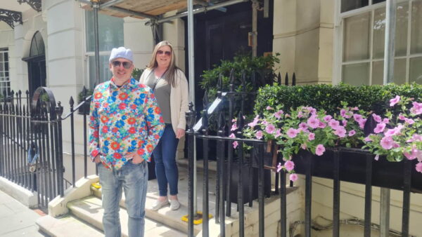 People enjoying a London Sightseeing One Day tour with a taxi service in front of a classic London townhouse