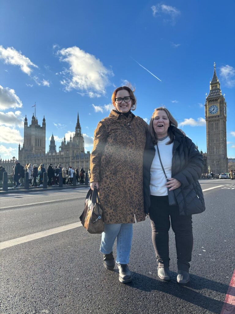 Sightseeing London In A Day - Tourists posing in front of Big Ben and the Houses of Parliament on a sunny day
