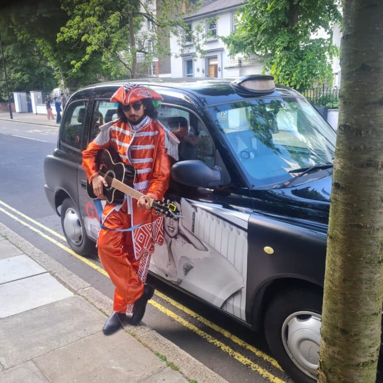 London Walking Guides performer in vibrant costume playing guitar by black cab