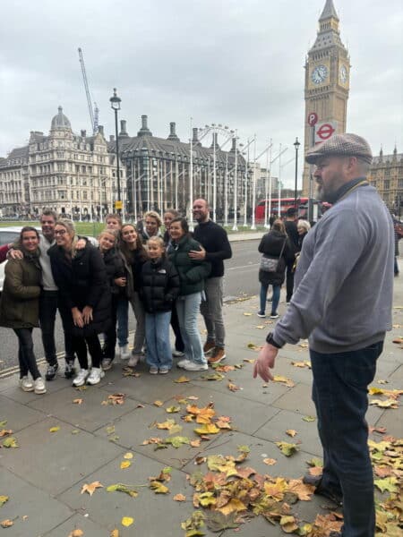 Group of tourists posing near Big Ben during a London Sightseeing Taxi Tour, highlighting new places to visit in London