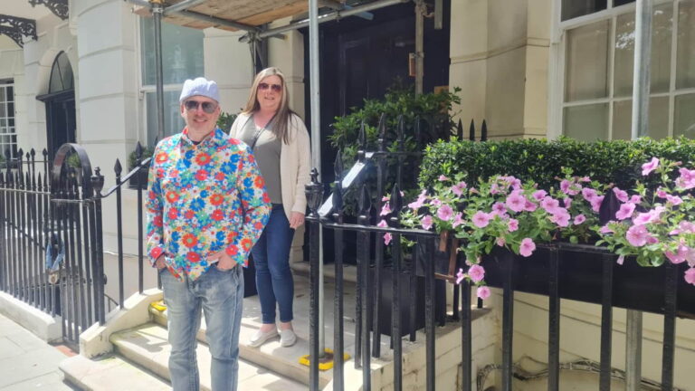Tourists outside a famous place in London during a sightseeing taxi tour