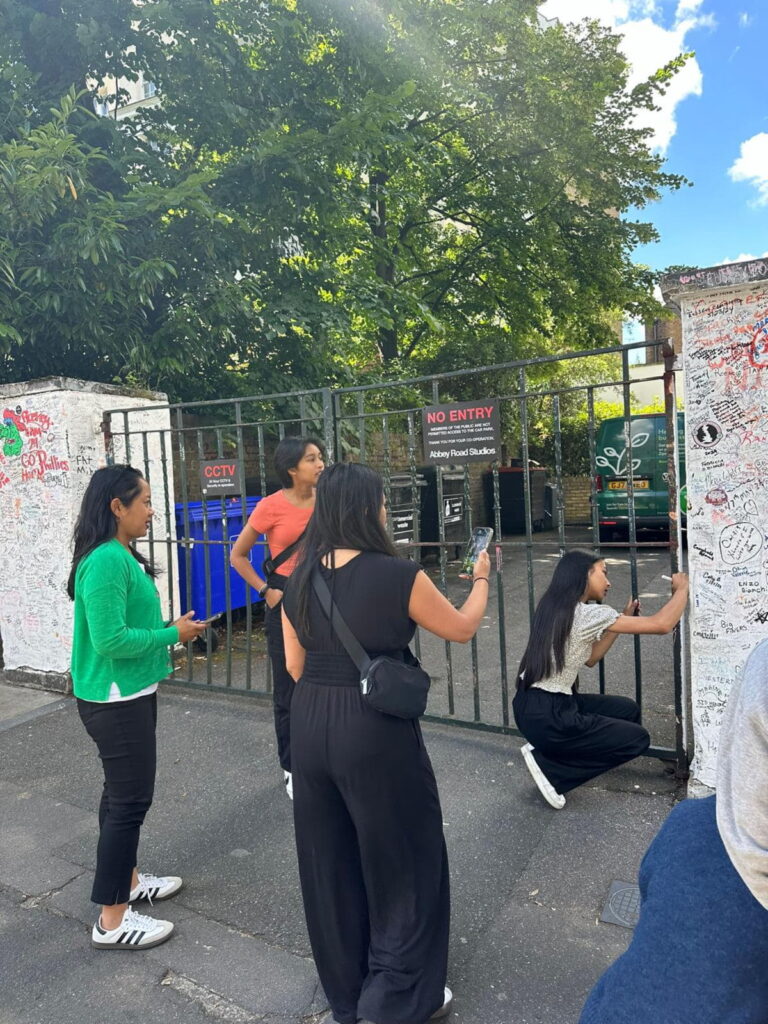 Group of tourists exploring Abbey Road Studios, a cool attraction in London with London Sightseeing Taxi Tours