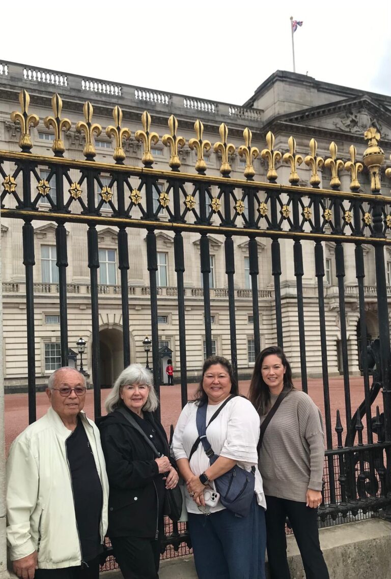 Visitors posing at Buckingham Palace, one of the most visited places in London, during a London Sightseeing Taxi Tour