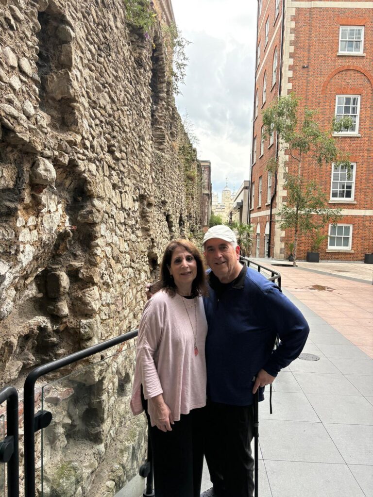 Couple enjoying London Weekend Itinerary next to an ancient wall
