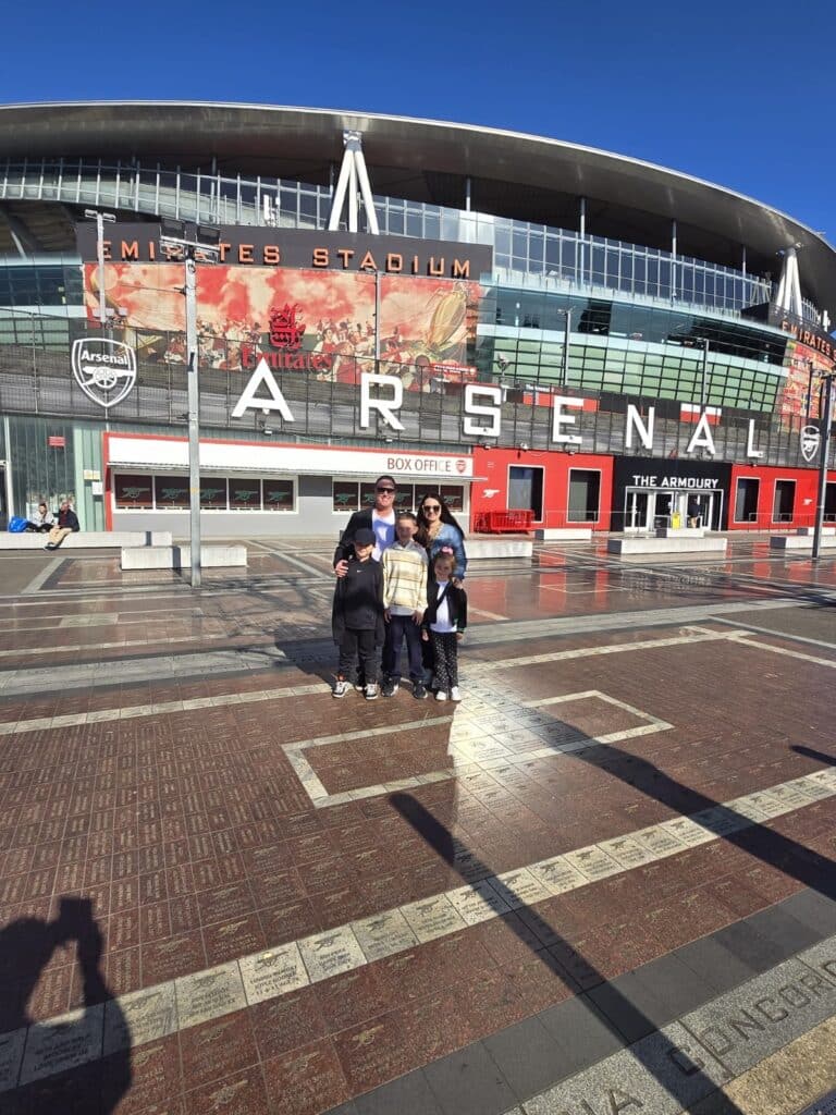 Group standing outside Emirates Stadium, a must-see London attraction, featured in Places You Must See In London