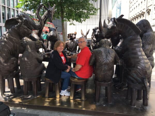 Visitors enjoying a city tour london at iconic animal statues in the heart of the city