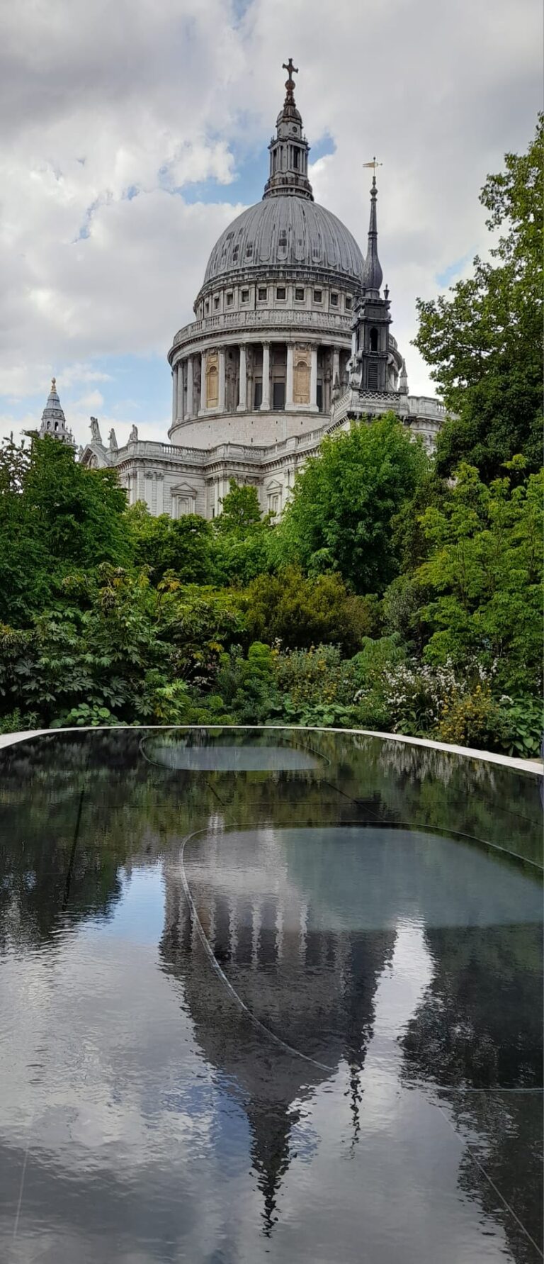 London excursions day trips featuring iconic St. Paul's Cathedral viewed from a serene garden with reflection in water during sightseeing taxi tours
