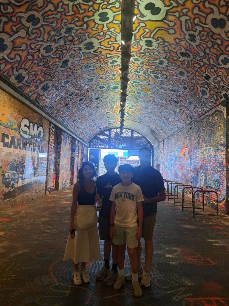 Family group discovering vibrant street art in London's Leake Street Arches during the best London walking tours