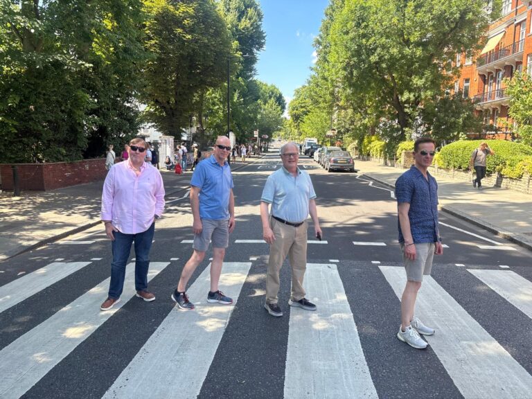 group enjoying london excursions at Abbey Road crossing during a London Sightseeing Taxi Tour
