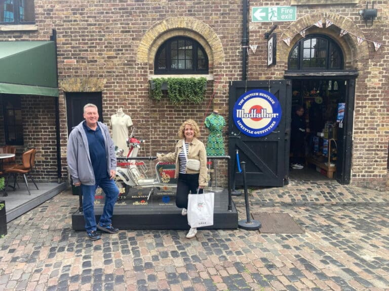 guided tours passengers enjoying London Sightseeing Taxi Tours outside a historic brick storefront