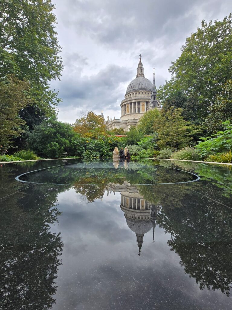 Tours in London UK: Visitors enjoying London sightseeing taxi tours at St. Paul's Cathedral with stunning water reflection