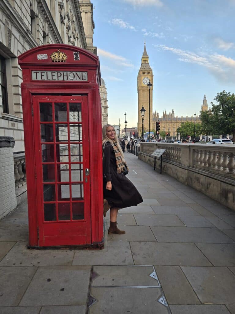 Tourist posing with red phone booth and Big Ben during small group tours London sightseeing experience