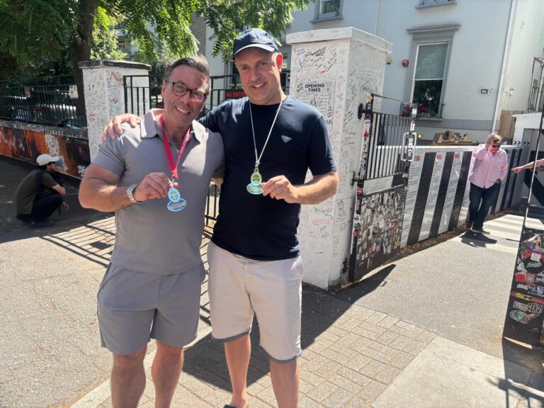 Group enjoying bus tour London with medals from London Sightseeing Tours, exploring iconic landmarks
