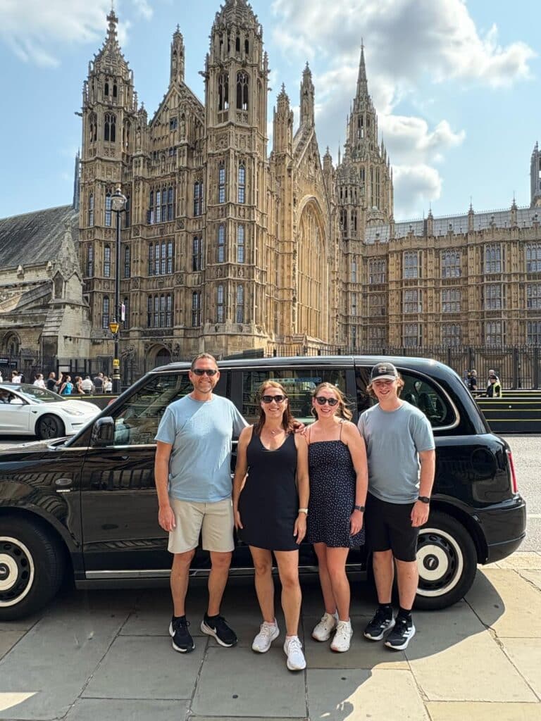 Best UK tour companies: Family posing with black cab outside Houses of Parliament on London Sightseeing Taxi Tours