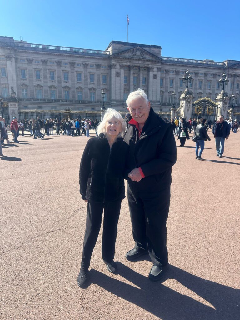 Happy family posing in front of Buckingham Palace during the best London tours for families with London Sightseeing Taxi Tours, accessible and affordable for groups up to six