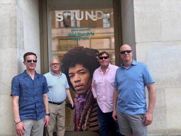 london excursions packages: Tourists posing in front of Jimi Hendrix mural during London sightseeing taxi tours, accessible for up to six people