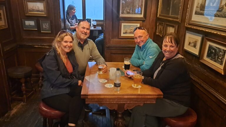 Group enjoying premium tours harry potter in a cozy London pub after sightseeing taxi tour