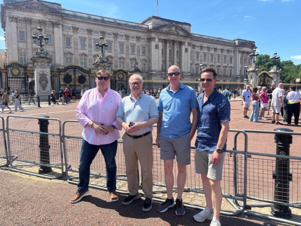 Group of friends enjoying a personal tour guide in London with London Sightseeing Taxi Tours at Buckingham Palace