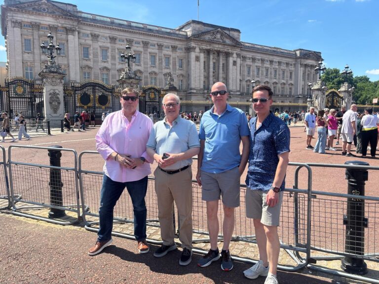 Group of friends enjoying a personal tour guide in London with London Sightseeing Taxi Tours at Buckingham Palace