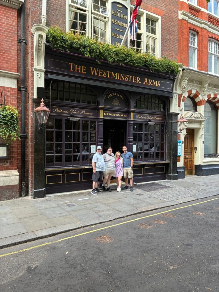 escorted tours of london group posing outside historic Westminster Arms pub during sightseeing taxi tour