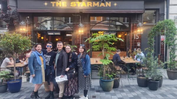Group enjoying the cheapest London bus tour, exploring iconic spots like The Starmans pub with London Sightseeing Taxi Tours for budget-friendly sightseeing