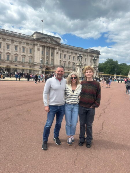 Best tours to do in London: A family enjoying a sightseeing taxi tour in front of iconic Buckingham Palace, perfect for groups up to six with wheelchair accessibility