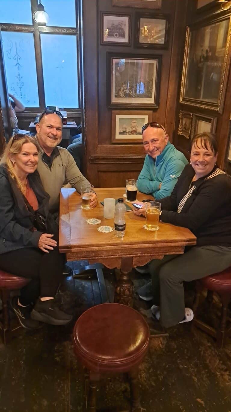 Group of visitors relaxing in a traditional pub during day tour to Stonehenge from London with London Sightseeing Taxi Tours